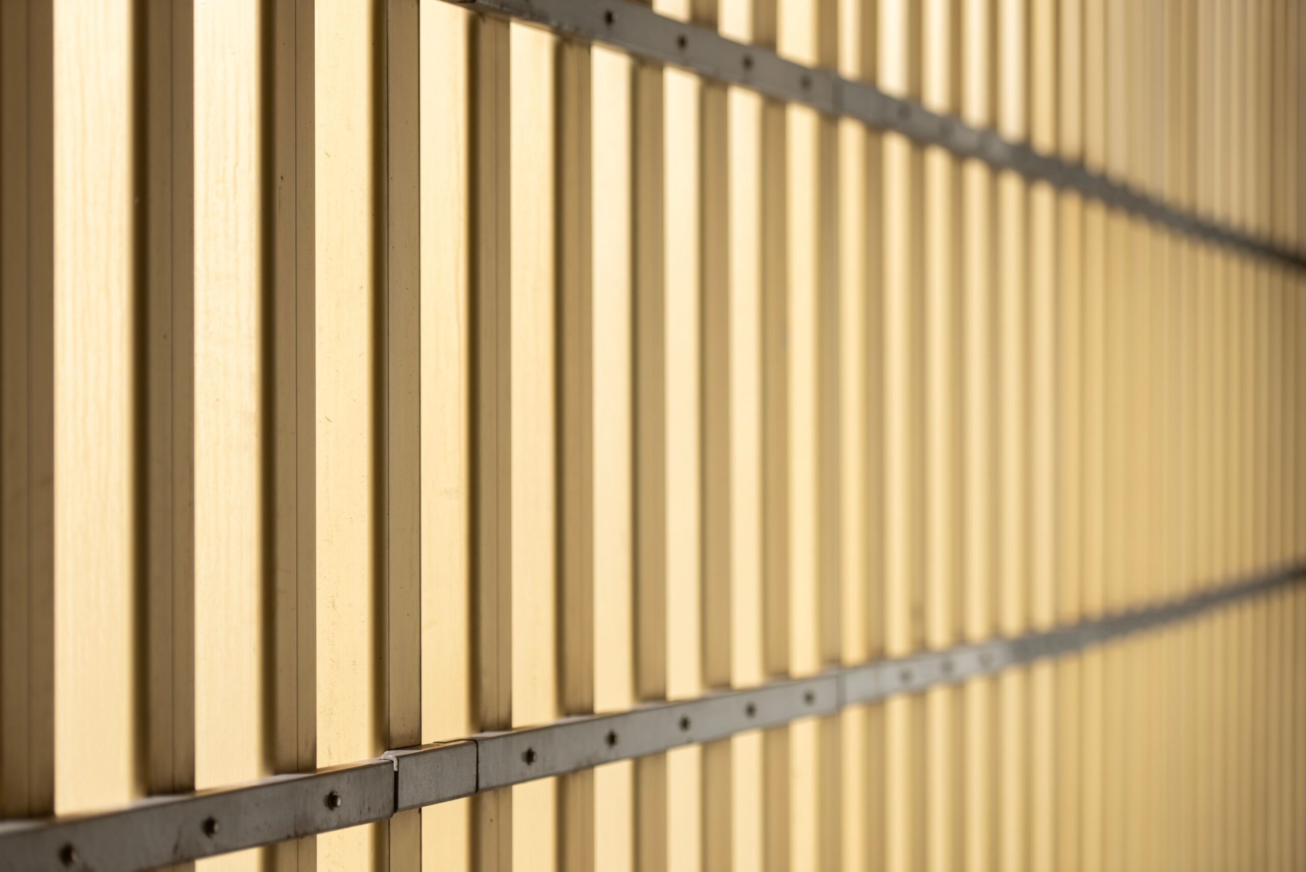 Close-up of a repeating pattern on a modern, industrial-style wall with warm beige tones.